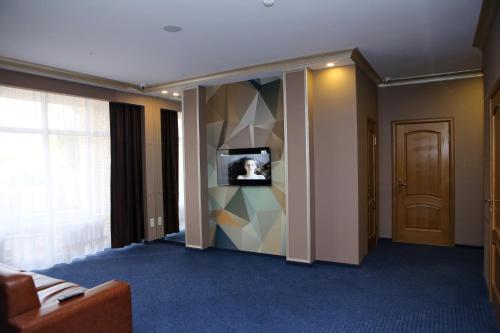 a hotel room with a television and a room with a door at Hotel Aner in Astana
