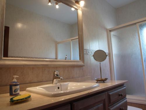 a bathroom with a sink and a large mirror at Can La Villa in Pollença