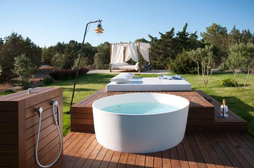 a bath tub sitting on a deck with a bed at Villas Paraíso de los Pinos in Sant Francesc Xavier