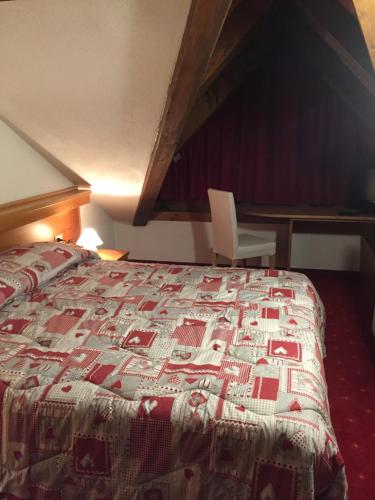 a bedroom with a bed with a quilt on it at Rauzi Hotel Garnì & apartments in Malè