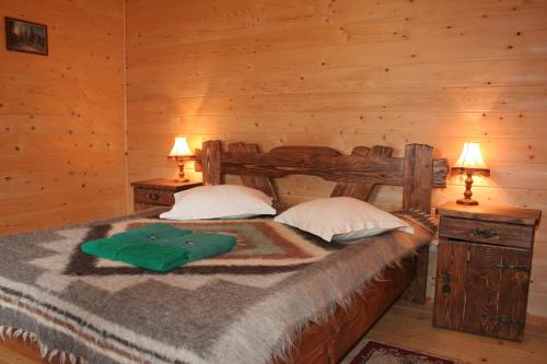 1 dormitorio con 1 cama en una cabaña de madera en On Dovbush Path, en Yaremche