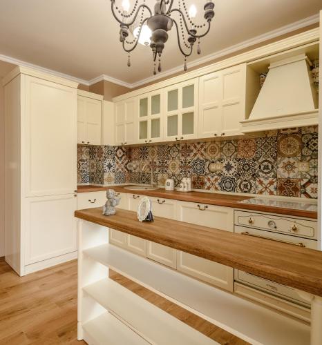 a kitchen with white cabinets and a chandelier at CasaAparta in Sofia