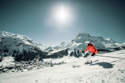 a person is skiing down a snow covered mountain at Hinterwies – Ski In / Lodge / Dine in Lech am Arlberg