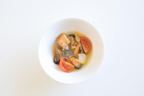 a white bowl of soup with mushrooms and tomatoes at Grand Hotel Palace in Ancona