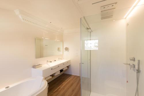 a white bathroom with a sink and a shower at Grand Hotel Palace in Ancona