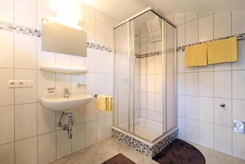 a bathroom with a glass shower and a sink at Lanzenbauernhof in Going am Wilden Kaiser