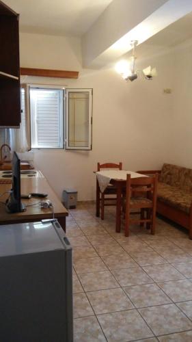 a kitchen and living room with a table and a couch at Elena Apartament in Sarandë