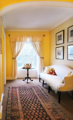 a yellow room with a bed and a window at Ballymote Country House in Downpatrick