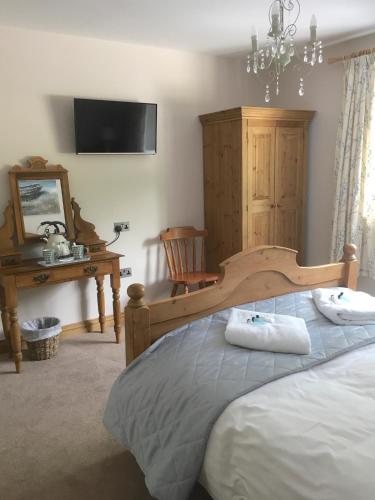 a bedroom with a bed with two towels on it at The Waterwheel in St Austell