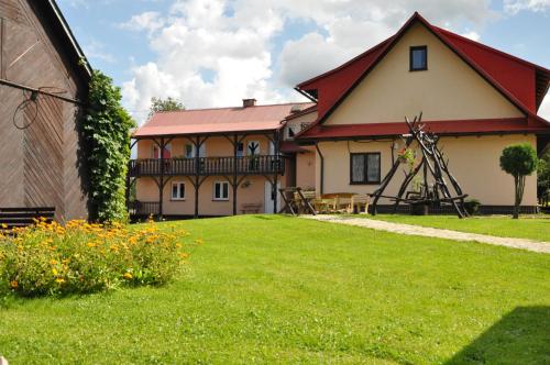 uma casa com um telhado vermelho e um jardim de relva em Nad Krolówką em Ustrzyki Dolne