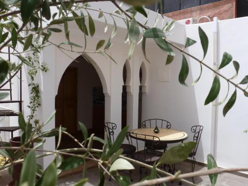 eine Terrasse mit einem Tisch und Stühlen in einem Gebäude in der Unterkunft Riad Safina in Marrakesch