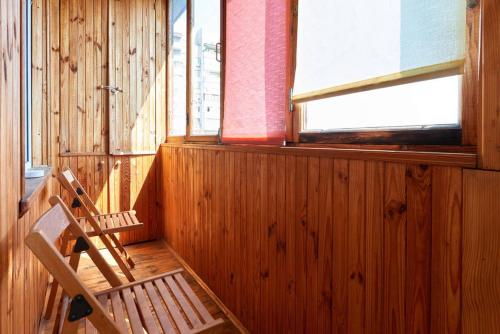 a wooden room with a bench and a window at Home Hotel Apartments on Livoberezhna in Kyiv