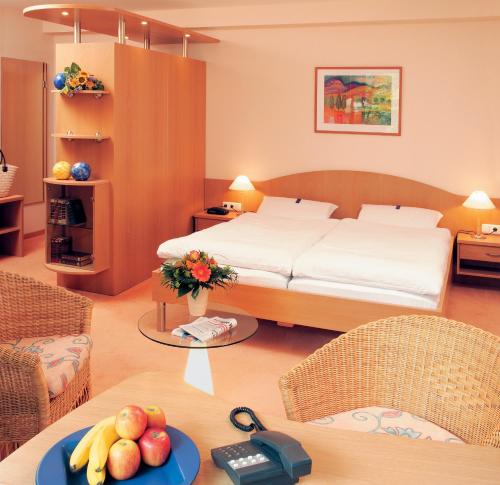 a bedroom with a bed and a table with fruit on it at Moorland Hotel am Senkelteich in Vlotho