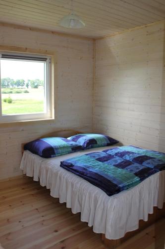 a bed in a room with a window at Domki pokoje pod Wierzba in Sarbinowo