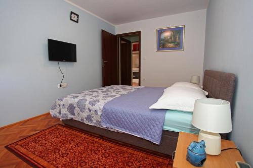 a bedroom with a bed and a table with a lamp at Apartment Marko 1 in Split