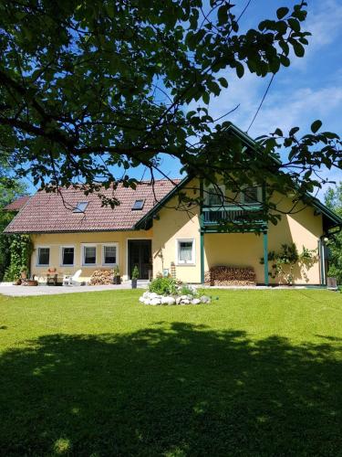 a house with a green lawn in front of it at Landhaus HALLSTATT FEELING - Apartment - Self Check-in in Bad Goisern