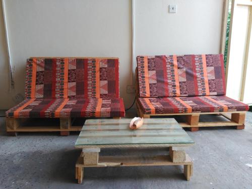 2 Stühle und ein Couchtisch in einem Zimmer in der Unterkunft Sarawally Guesthouse in Ampaya