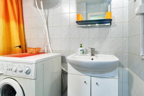 a bathroom with a sink and a washing machine at Home Hotel Apartments on Kontraktova Ploshcha in Kyiv