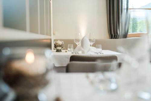 a table with a white table cloth and wine glasses at Zum Hirschen Boutique Hotel Val di Non in Unsere Liebe Frau im Walde