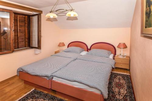 1 dormitorio con 1 cama, 2 lámparas y ventana en Apartment Vrilo, en Otočac
