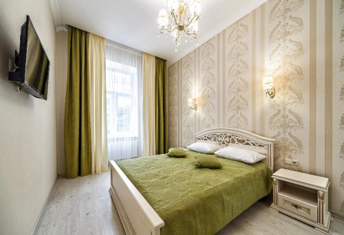 a bedroom with a bed and a chandelier at American Apartment in Lviv