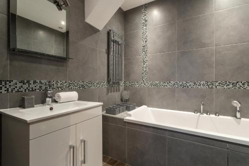 un baño con lavabo y bañera en Villa Loppe - Chamonix Mountain Four-Bedroom Hidden Gem, en Chamonix-Mont-Blanc