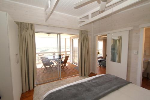 una camera da letto con un letto e un balcone con un tavolo di Big Sky Cottages a Wolseley
