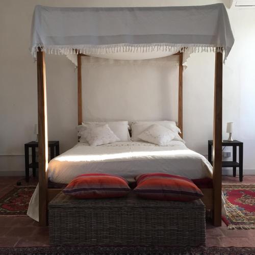 a bedroom with a canopy bed with two pillows at B&B Corte Vo Grande Vo di Bagno in Pegognaga
