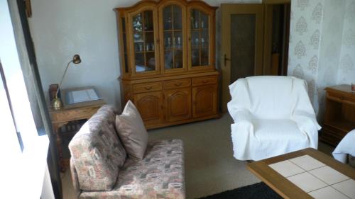 a living room with a couch and a chair at 3 Sterne Ferienwohnungen Wachter in Bischofsgrün