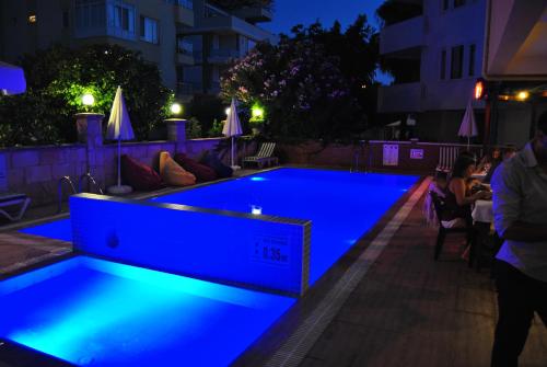 a swimming pool lit up at night at Benna Hotel in Antalya
