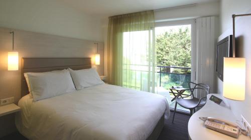 a hotel room with a bed and a window at ibis Styles Quiberon Centre in Quiberon