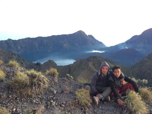two people sitting on top of a mountain at Tetebatu Indah Homestay in Tetebatu