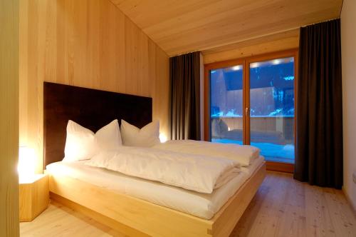 a bedroom with a large bed and a window at Montafon Chalets in Gaschurn