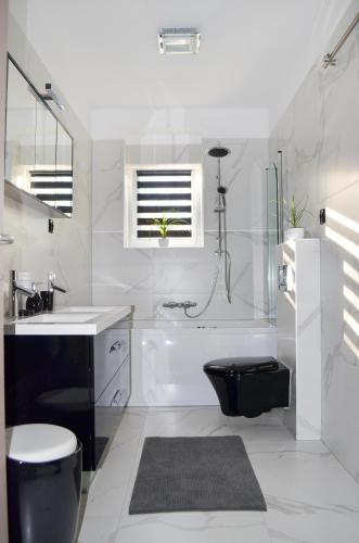 a bathroom with a tub and a toilet and a sink at TJ Apartment in Krk