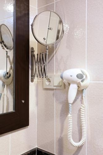 a bathroom with a blow dryer and a mirror at Arya Hotel Sakarya in Sakarya