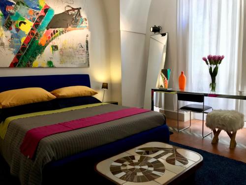 a bedroom with a bed and a desk and a painting at ART TO DESIGN B&B in Lecce