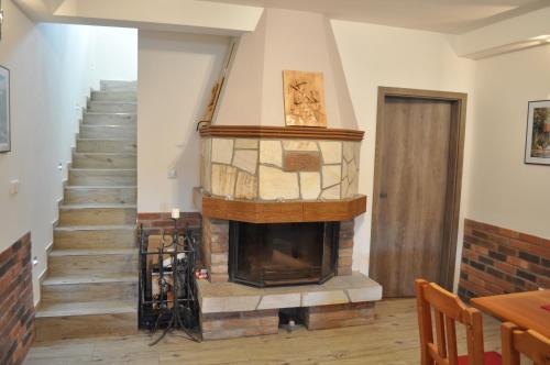 a living room with a fireplace and a staircase at Vinařství Herůfek in Zaječí