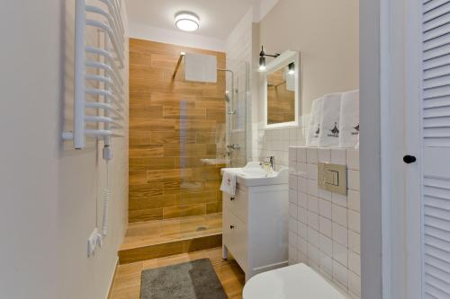 y baño blanco con lavabo y ducha. en Imperial Apartments - Classic by Hampton en Sopot