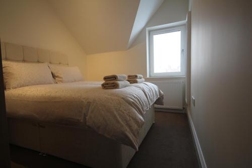 a bedroom with a bed with two towels on it at Sea View Apartments in South Shields