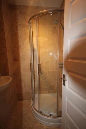 W łazience znajduje się prysznic ze szklanymi drzwiami. w obiekcie Sea View Apartments w mieście South Shields