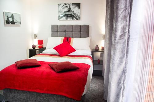a bedroom with a large bed with a red blanket at Trivelles Regency, Nottingham in Nottingham