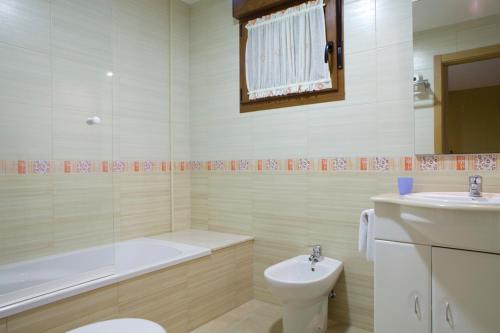 łazienka z wanną, toaletą i umywalką w obiekcie Sanxenxorural - Apartamentos La Rana w mieście Sanxenxo