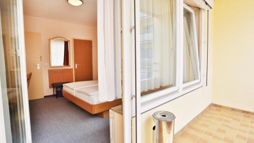 una piccola stanza con un letto e una finestra di Hotel Europa Pforzheim a Pforzheim