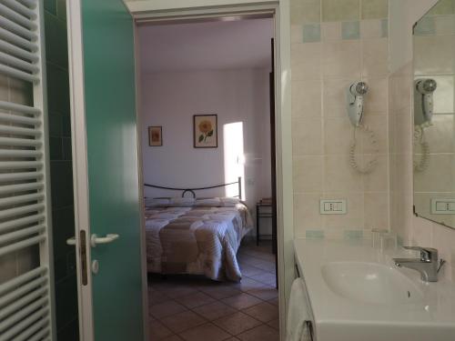 y baño con cama, bañera y lavamanos. en Agriturismo Villa Caprareccia, en Bibbona