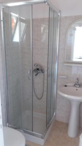 a glass shower in a bathroom with a sink at Giannis Studios in Alykes