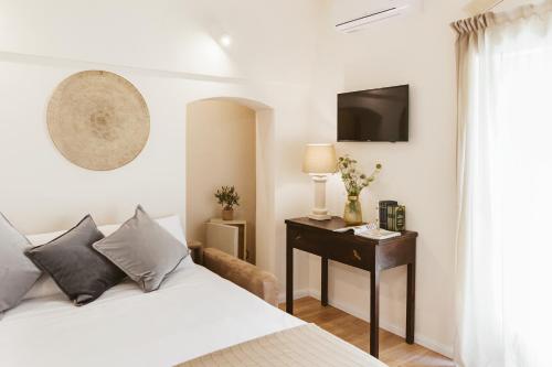 1 dormitorio con 1 cama y escritorio con TV en Miramonte Holiday, en Montescaglioso