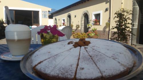 a cake sitting on a table with a drink at Villa Laura Apartment in Giardini Naxos