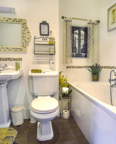 a bathroom with a toilet and a tub and a sink at Mama’s Inn Boutique Guest House in Nottingham