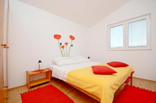 a bedroom with a bed and a vase of flowers on the wall at Apartment Pavica in Rogoznica