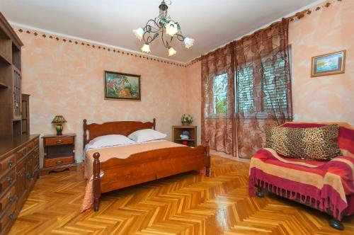 sypialnia z 2 łóżkami i żyrandolem w obiekcie Apartments Ljiljana w Rogoznicy